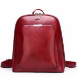 Kleine vintage rugzak in effen rood imitatieleer met witte achtergrond