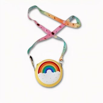 Regenboog handtas met brede, kleurrijke, verstelbare riem op een tafel met boeken.