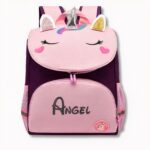 Paarse en roze kinderrugzak met eenhoornmotief en Angel op een lichtgrijze achtergrond