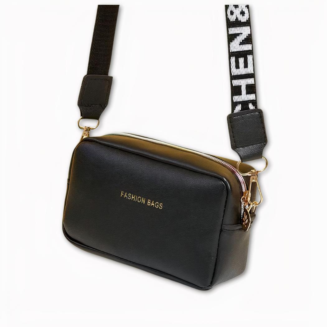 Foto van een schoudertas van een vrouw. De riem is afneembaar en op de voorkant van de tas staat 'Fashion bags'. De riem is afneembaar en op de voorkant van de tas staat 'Fashion bags'. De rits- en karabijnhaken aan de riem zijn goudkleurig. Het oppervlak is licht.