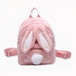 Roze pluche kinderrugzak met konijnenoren en pomponstaart op de voorkant.